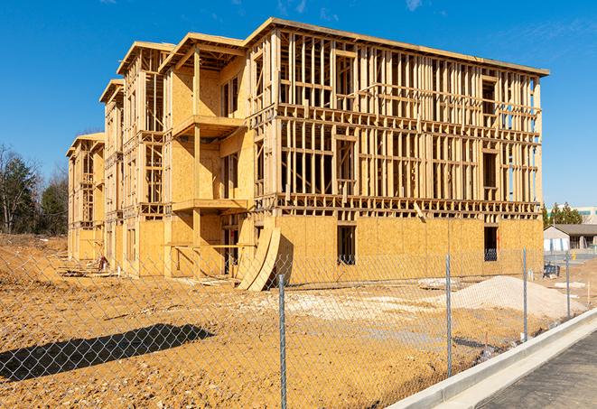 workers protected by temporary barrier fence during building maintenance in Highland Beach